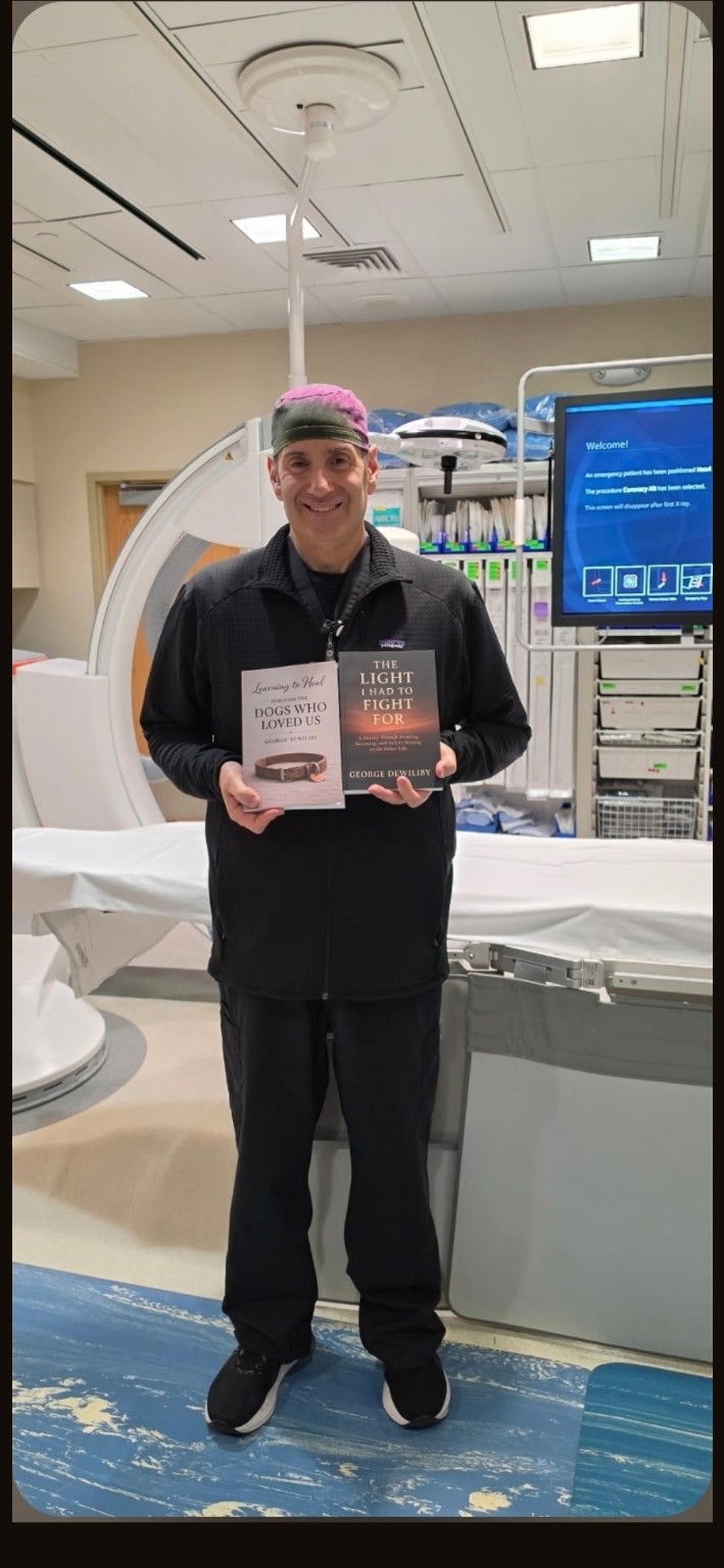 George Dewiliby holding his two published books